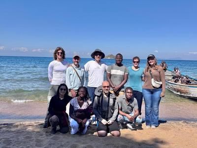 Group photo close to the Malawi Lake, which is the fourth largest freshwater lake in the world by volume, the ninth largest lake in the world by area and the third largest and second deepest lake in Africa.